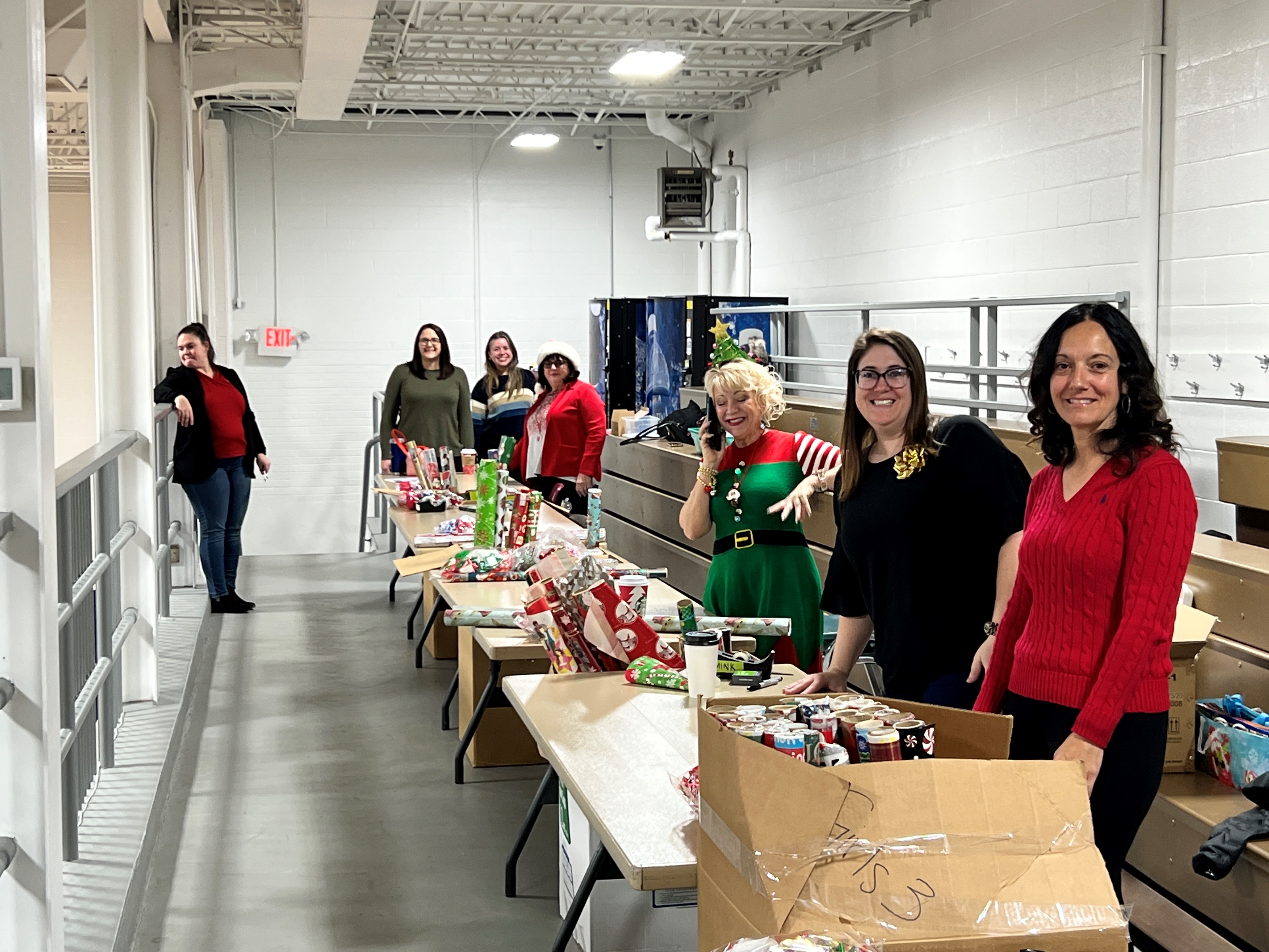 women standing in a row wrapping gifts