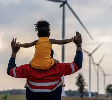 Father holding daughter while walking.