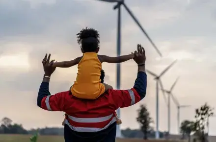 Father holding daughter while walking.