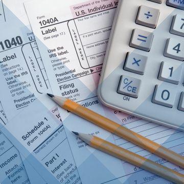 Tax paperwork, calculator, and pencils
