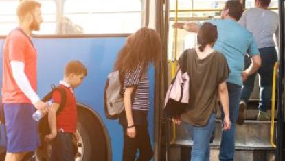 Six people getting onto a blue public bus